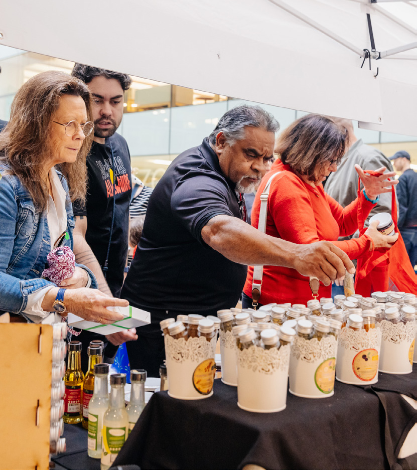 Shoppers browsing handmade bushfood products at a market stall